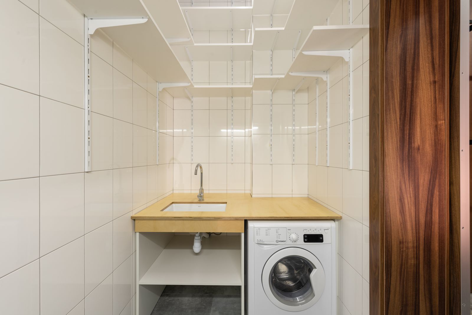 غسالة ملابس أوتوماتيك أمامية في غرفة غسيل منزلية — front-load automatic washing machine in a home laundry room